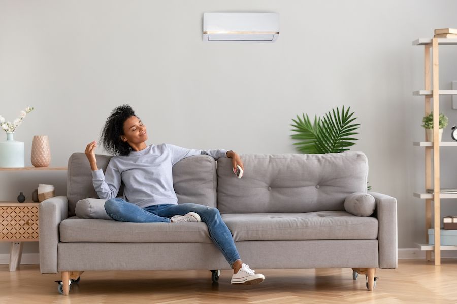 A woman relaxes on a couch. What Do Air Purifiers and Air Filters Do?