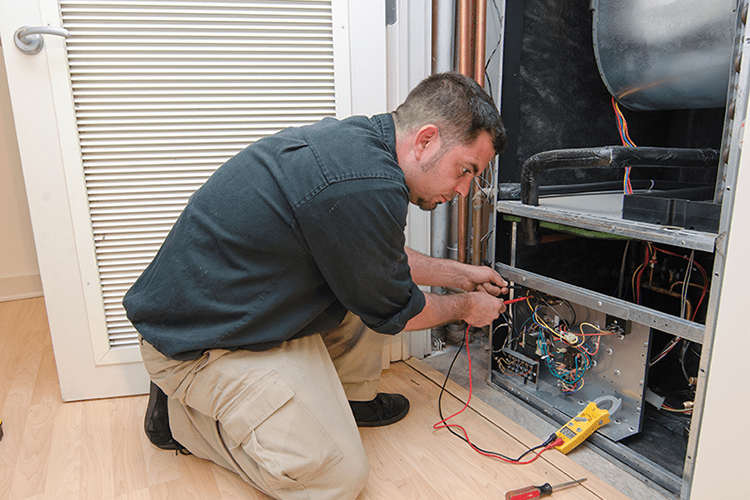 A man works on a ductless system. What Maintenance Is Needed for a Ductless System?